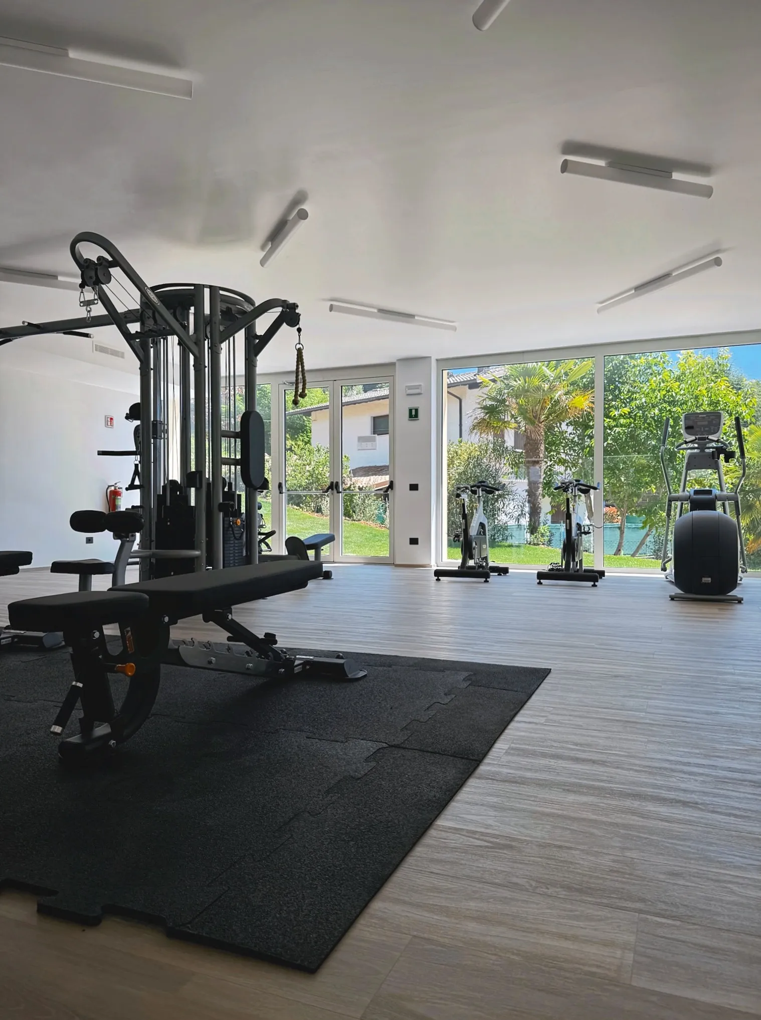 Fitnessraum – Übersicht mit Cardio-Geräten und Gartenblick
