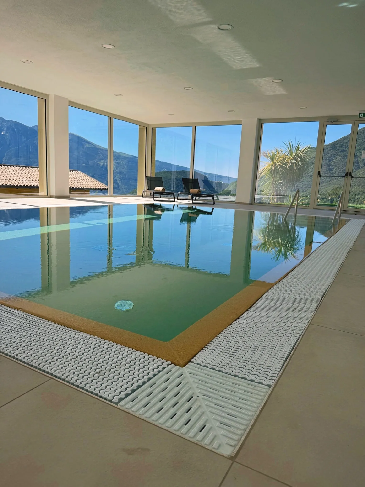 Indoor-Pool mit Panoramablick auf die Berge durch die Glasfront