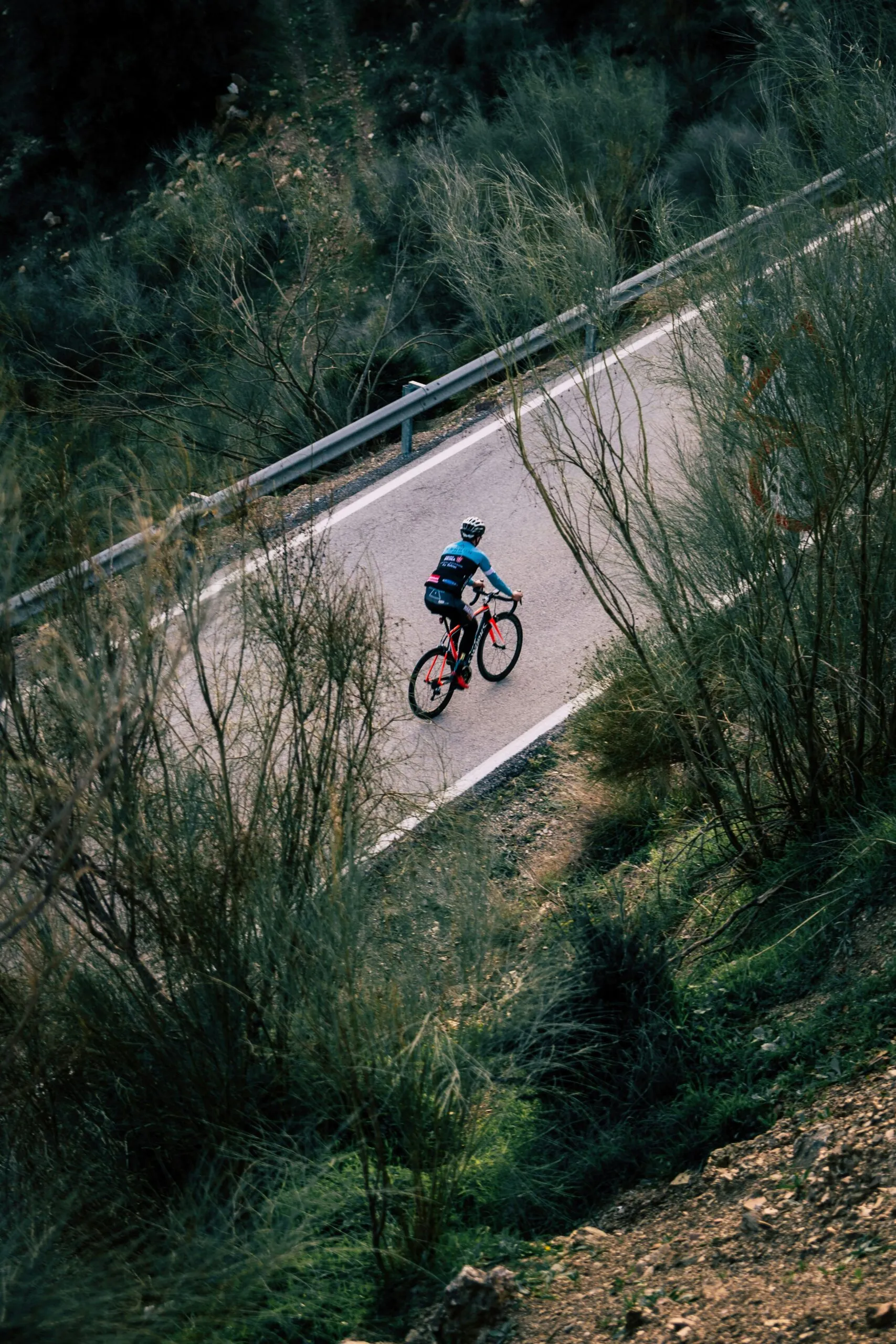 Road cyclist on a winding road along Lake Garda